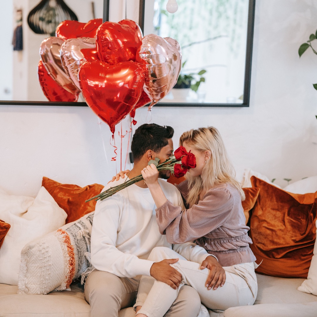 Rosen zum Valentinstag – Paar mit Rosen und Herzballons